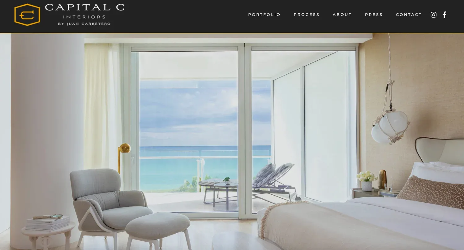 Luxurious beachfront bedroom with floor-to-ocean views, light neutral palette, modern furnishings, and minimal styling by Juan J. Carretero.