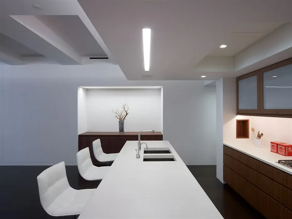 Modern office conference room with white table, black and white chairs, wood accents, and built-in shelving by Judith Gerrard.