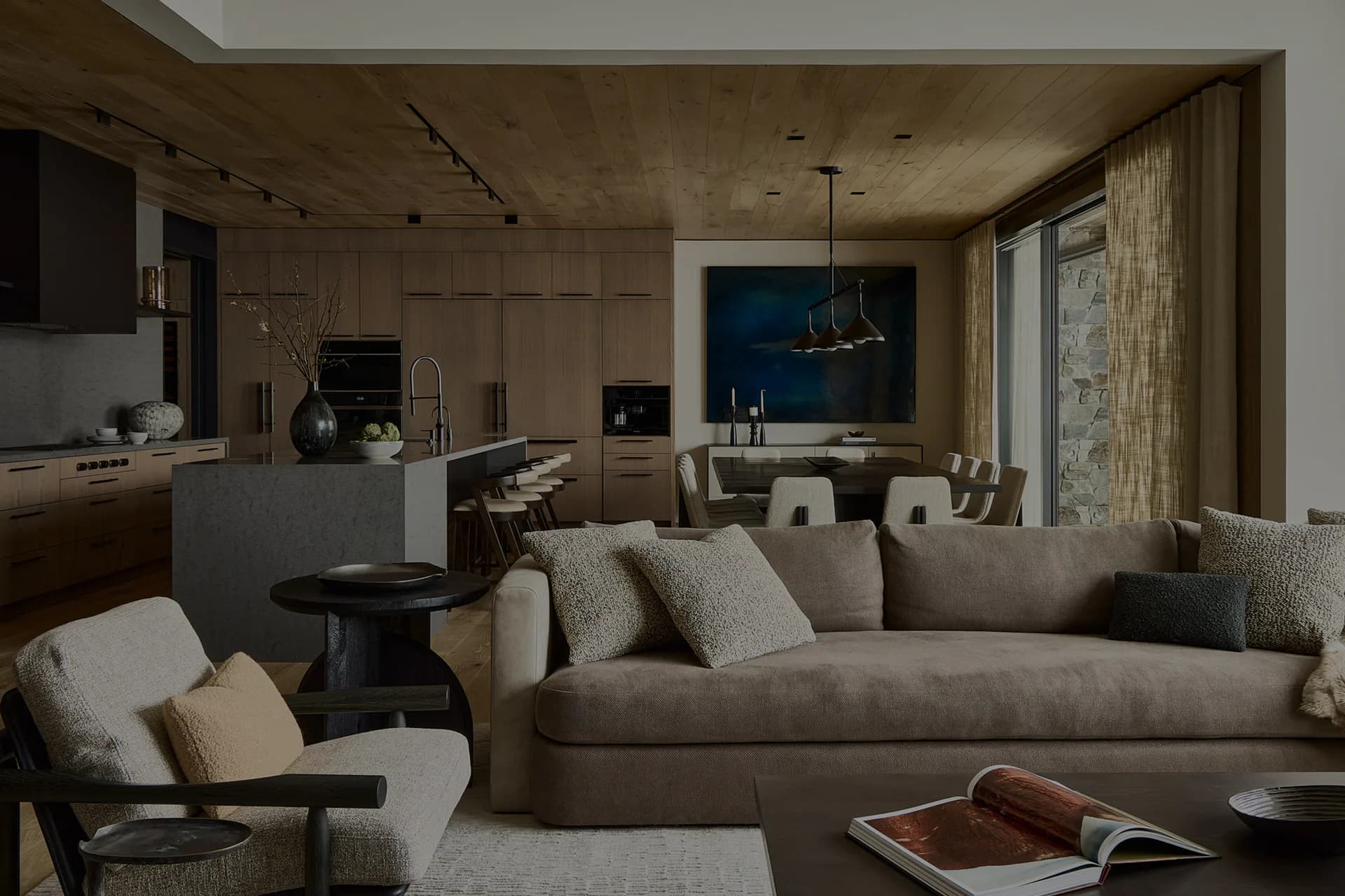 Modern living room with taupe sofa, natural materials, and blue accent wall, designed by Julia Turner.