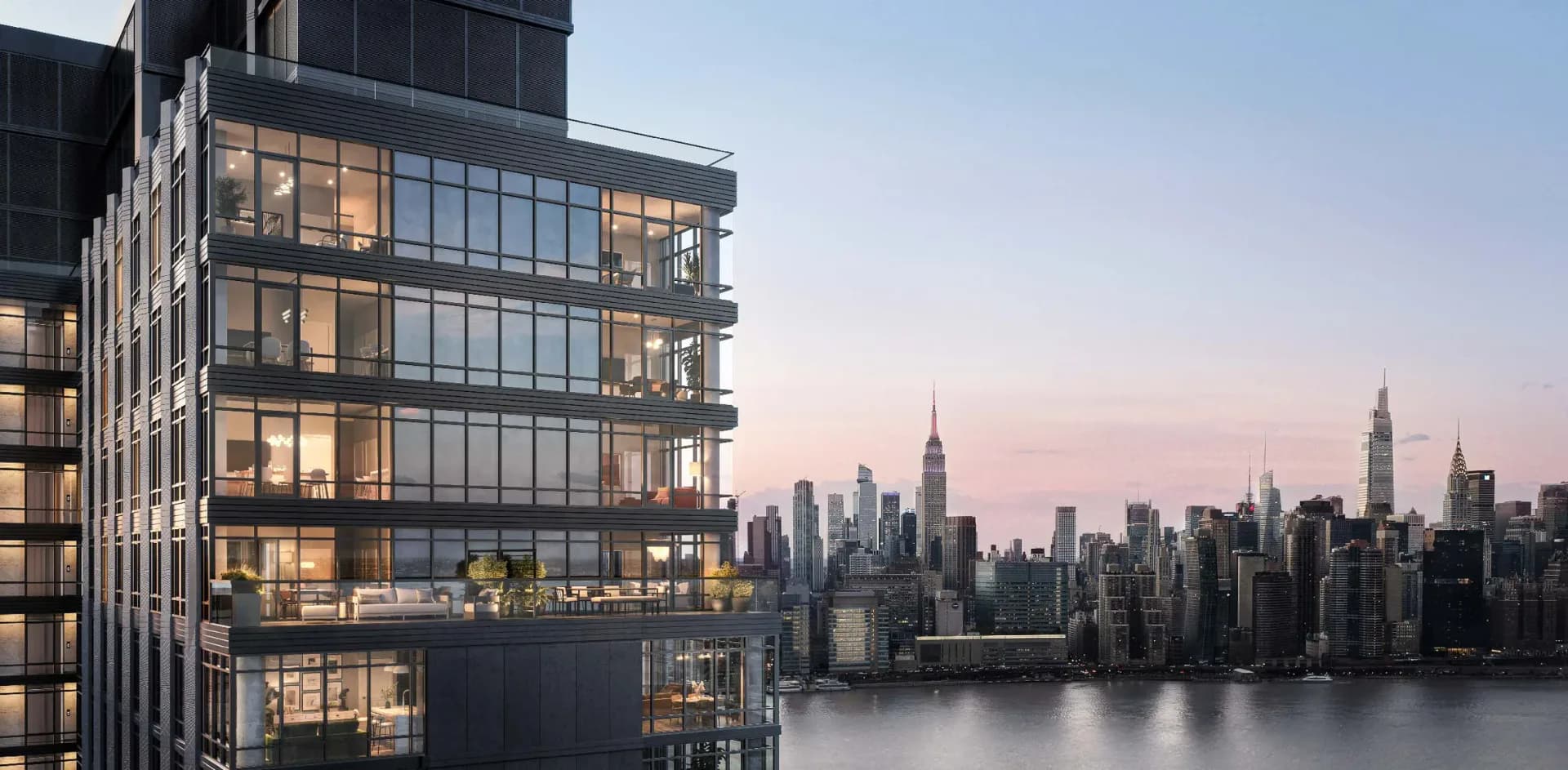 Modern residential building with illuminated interiors overlooking Manhattan skyline at dusk, designed by Jutta Ishii.