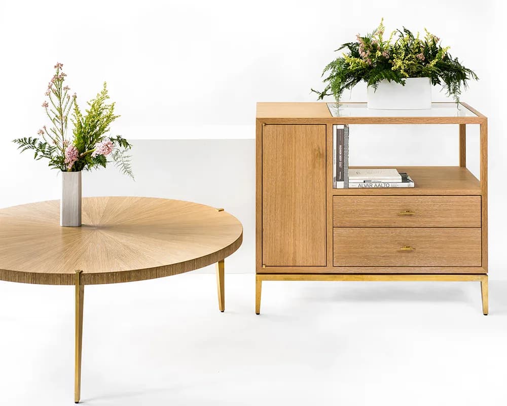 Light wood furniture collection featuring a round dining table with tapered legs, potted floral arrangement, and a mid-century modern storage cabinet with open shelving and hanging planter, designed by Kai-wei Hsu.