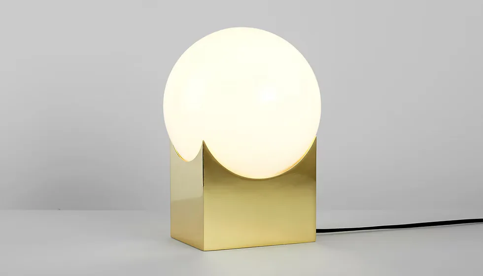 Minimalist brass cube lamp with large cream sphere diffuser on gray surface by Karl Zahn.