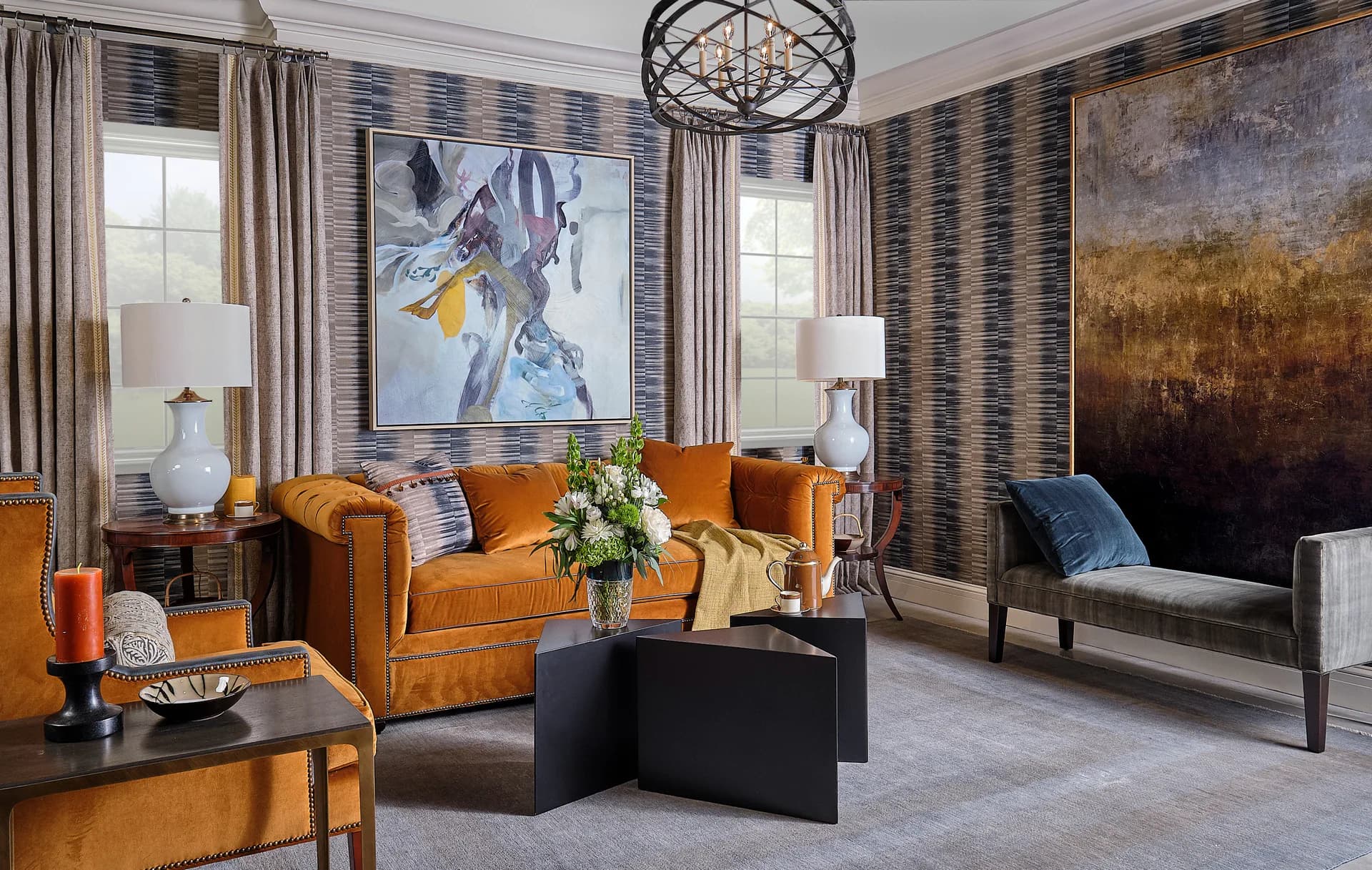 Luxurious living room featuring burnt-orange velvet seating, black lacquered coffee table, patterned wallpaper, and abstract artwork, designed by Keita Turner.