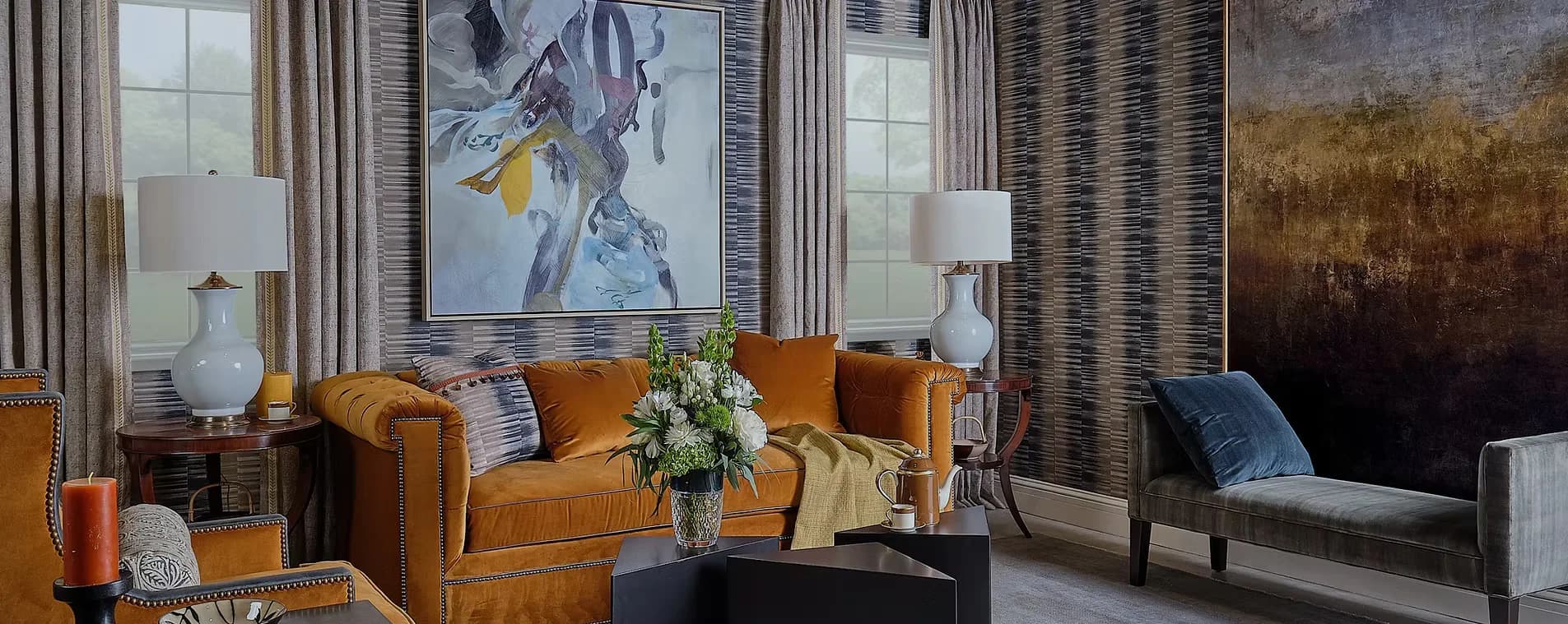 Contemporary living room with caramel leather sofa, warm ochre tones, marble accents, and modern artwork, designed by Keita Turner.
