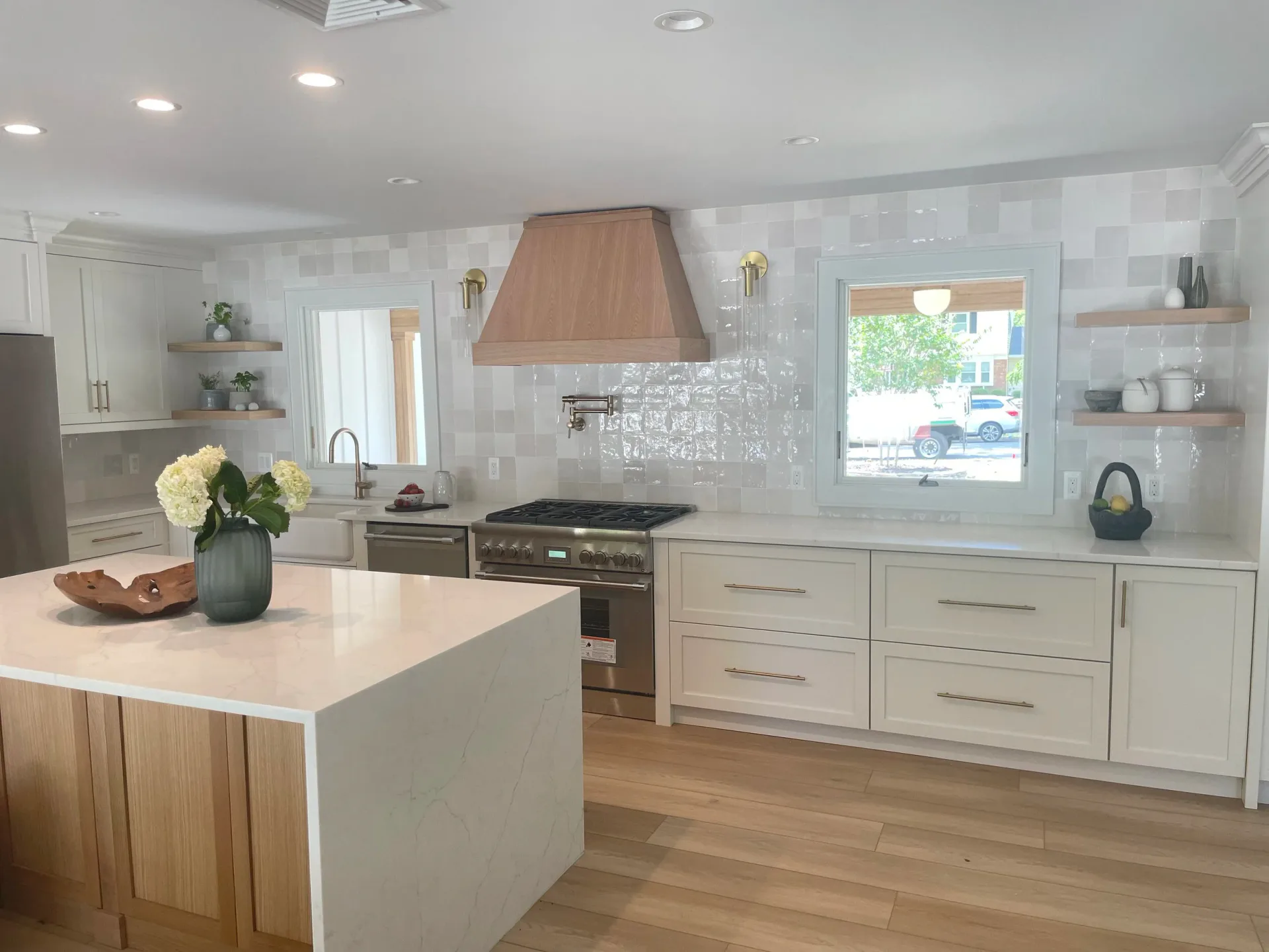 Modern kitchen with white cabinetry, white quartz countertops, wood island, subway tile backsplash, and copper range hood by Keri Tickle.