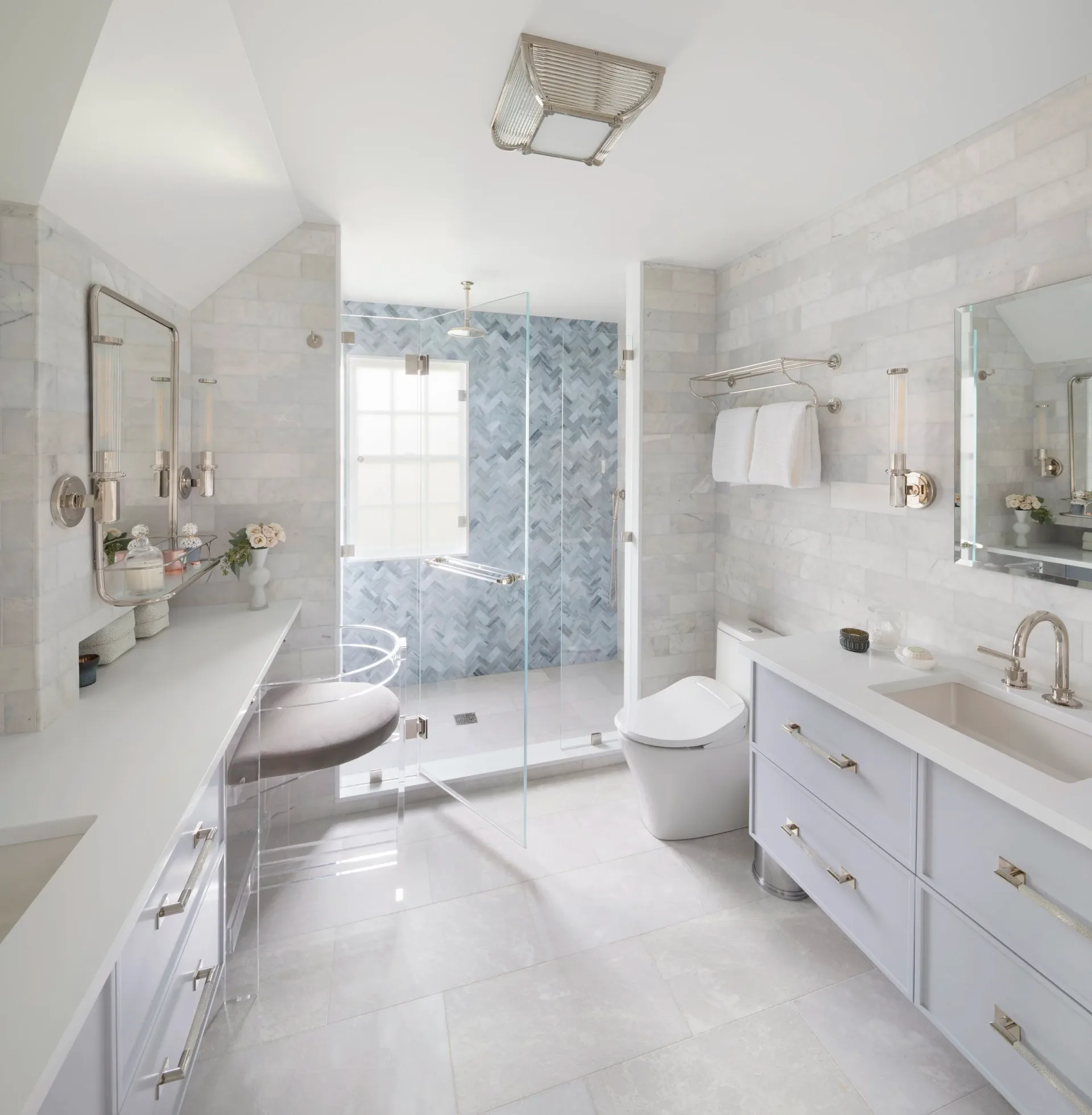 Luxurious primary bathroom with white cabinetry, marble countertops, and a walk-in shower with blue tile accent wall by Kim Mitchell.