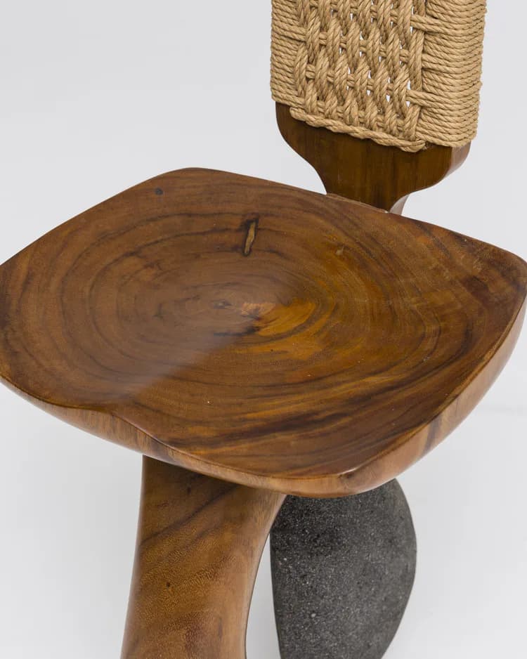 Sculptural wooden side table with organic, cross-sectional form and natural grain patterns, supported by a tapered wooden leg and stone base, by Kim Mupangilai.