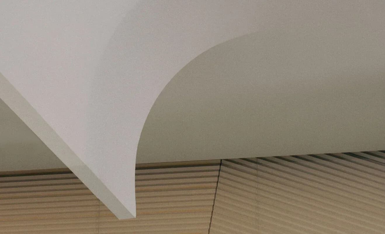 Minimalist interior with curved white architectural element and linear wooden ceiling detail by Lisa Dang.
