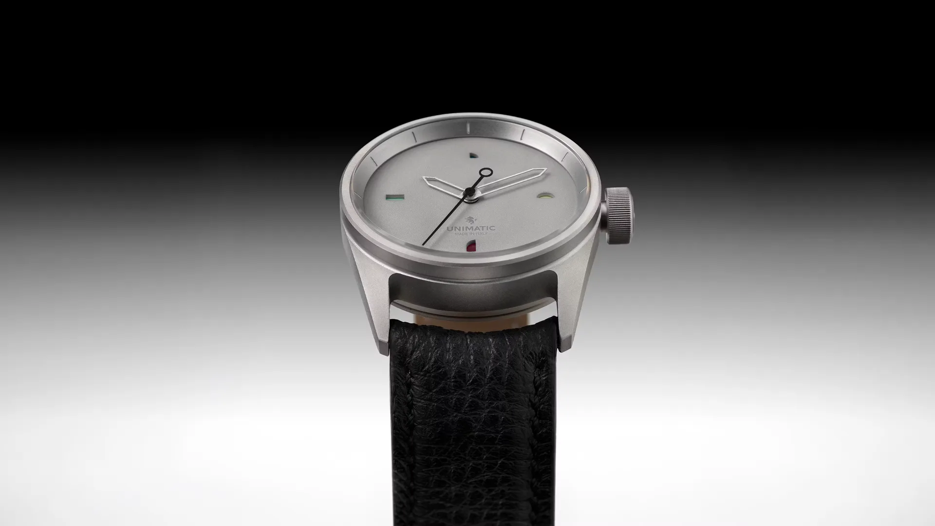 Minimalist wristwatch with round stainless steel case, clean dial, and black leather strap, product design by Luca Nichetto.