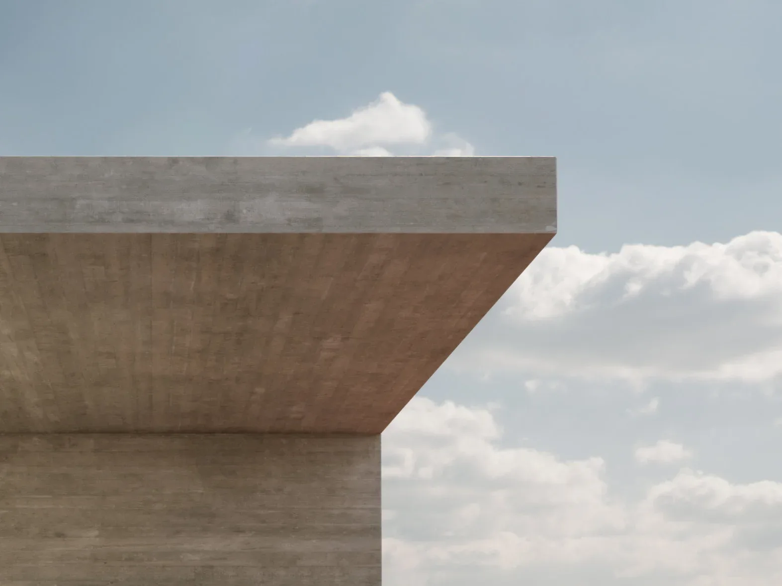 Minimalist concrete architectural structure with sharp geometric forms against a cloudy sky, by Marc Thorpe.