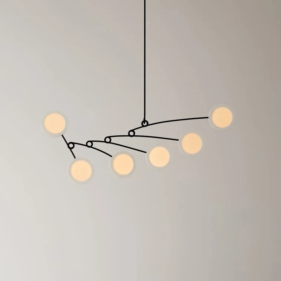 Modern pendant light fixture with multiple cream-colored glass spheres suspended from black metal arms by Mary Wallis.