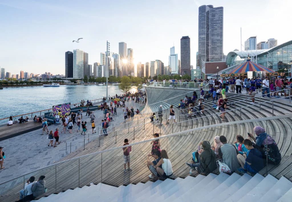 Waterfront plaza with amphitheater-style seating, public beach access, and Chicago skyline views by Mimi Hoang.