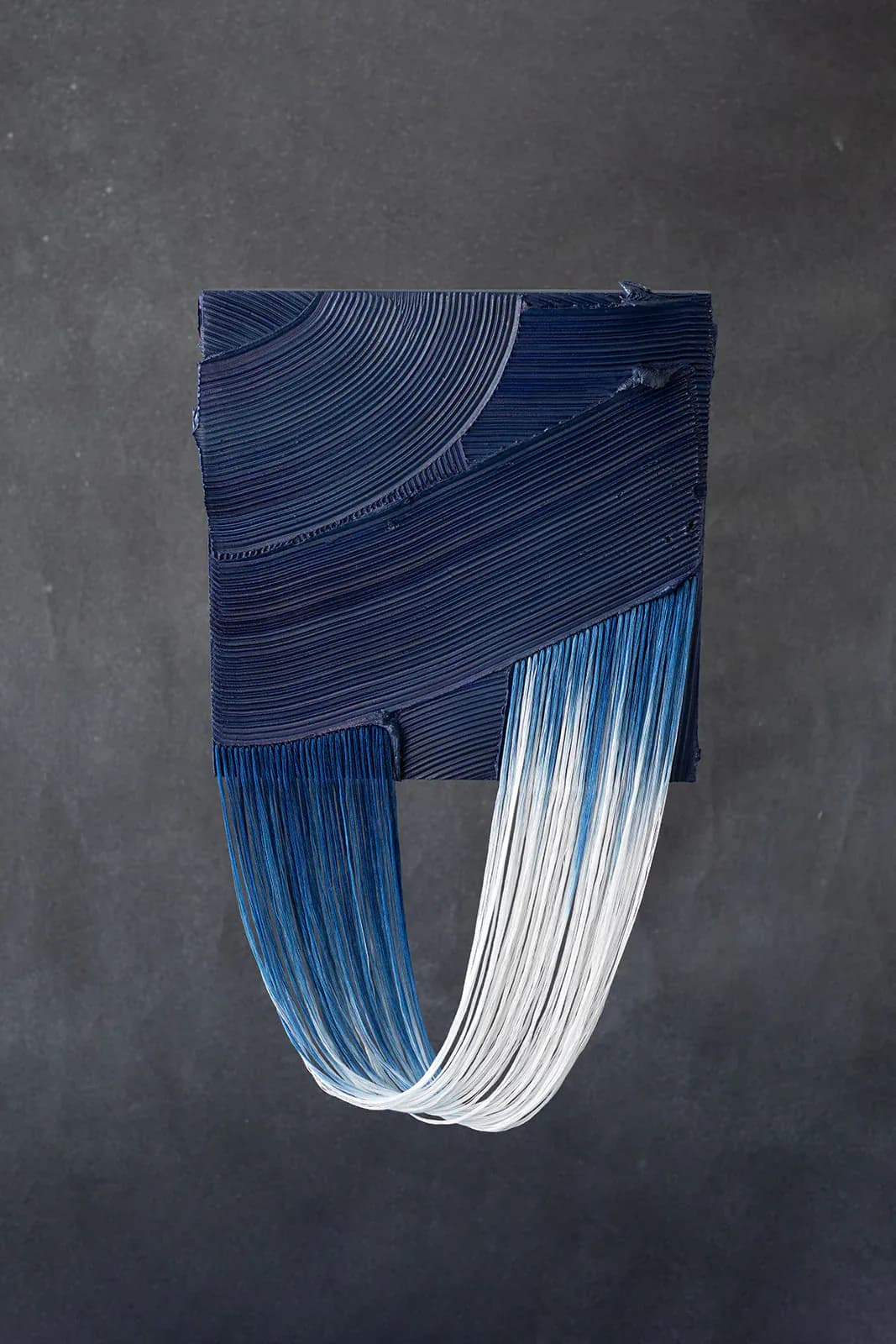 Abstract wall installation featuring layered blue and white striped elements with curved geometric forms creating dynamic movement and depth by Monica Curiel.