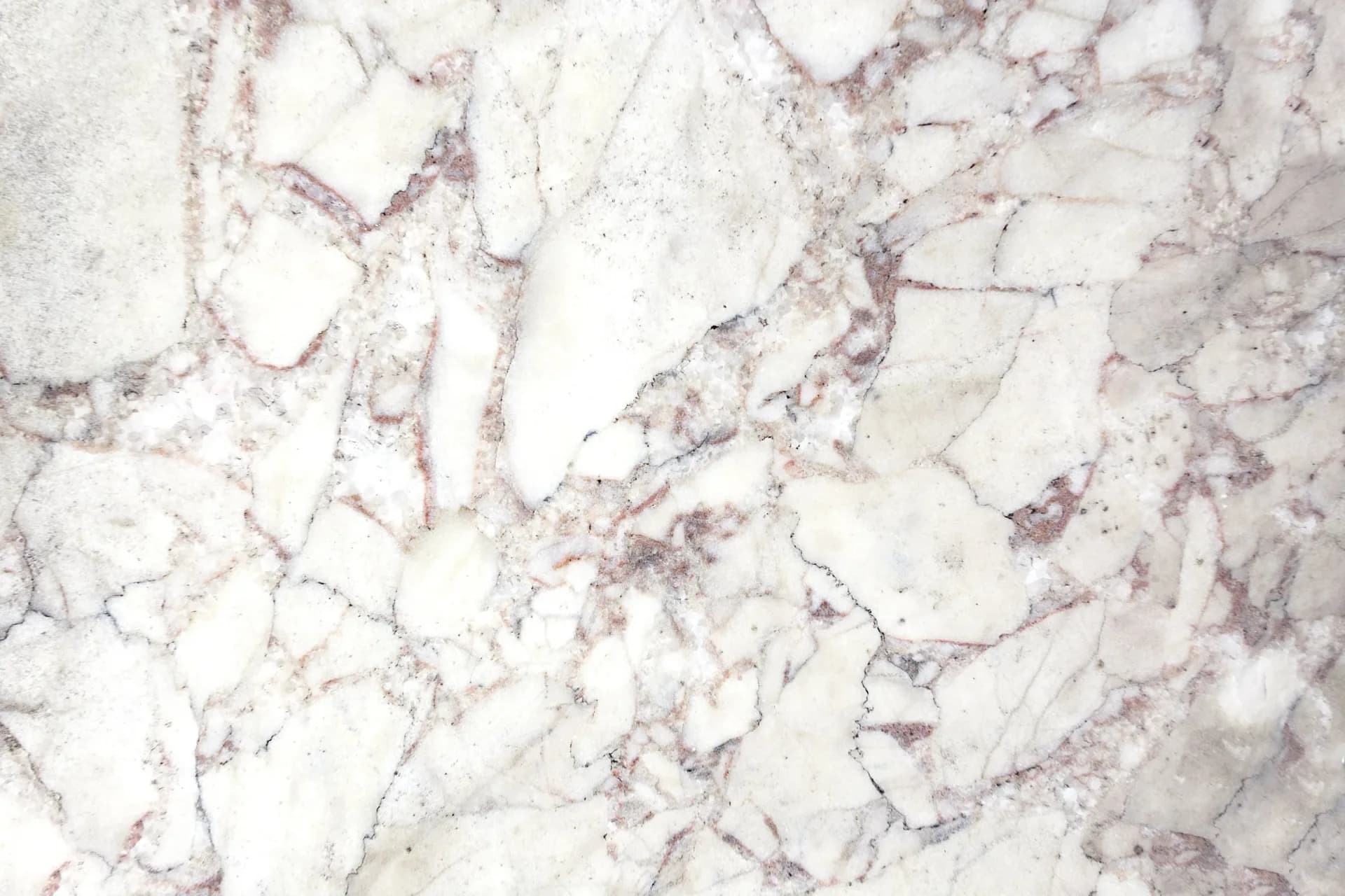 Close-up of a polished marble surface with white and soft pink veining, showcasing material selection and finish by Morgan Wendelborn.