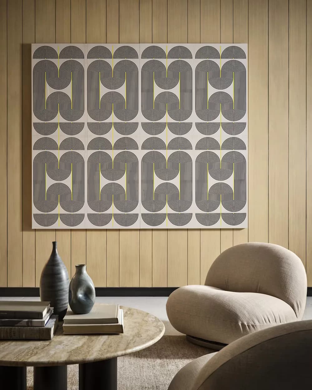 Mid-century modern living room with geometric patterned wall art, curved upholstered furniture, and minimalist wooden side table by Morris Adjmi.