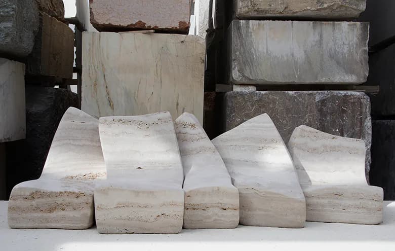Stacked white and cream travertine stone blocks with natural striations, arranged as a material study or product display by Najla El Zein.
