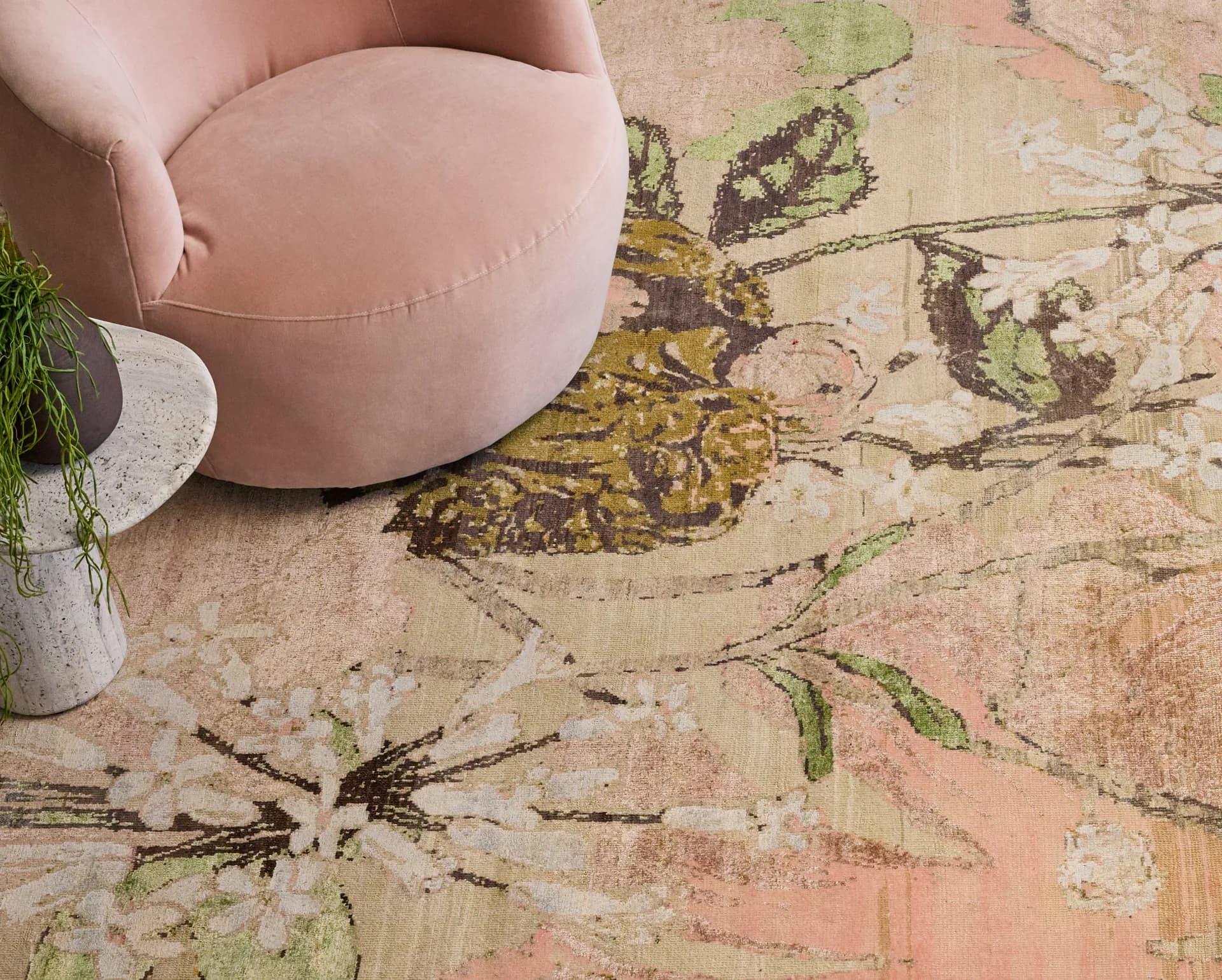 Terracotta floor with botanical ink drawings and a pink upholstered round pouf, styled interior design detail by Nicole Pierpont.