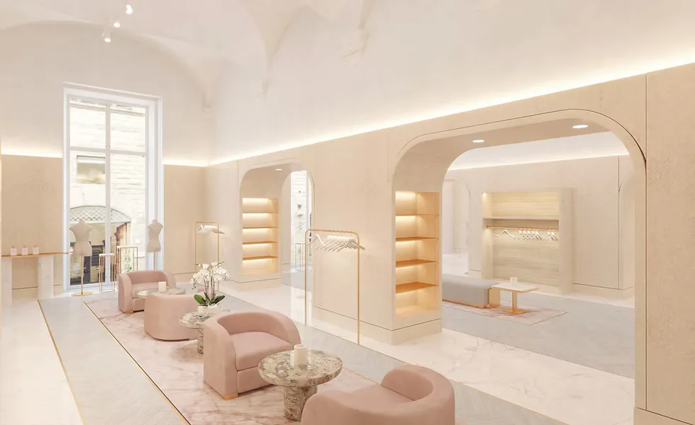 Luxurious spa or beauty salon interior with soft beige and cream tones, featuring curved architectural elements, warm ambient lighting, plush pink seating, and illuminated storage niches, designed by Nitzan Tagansky.