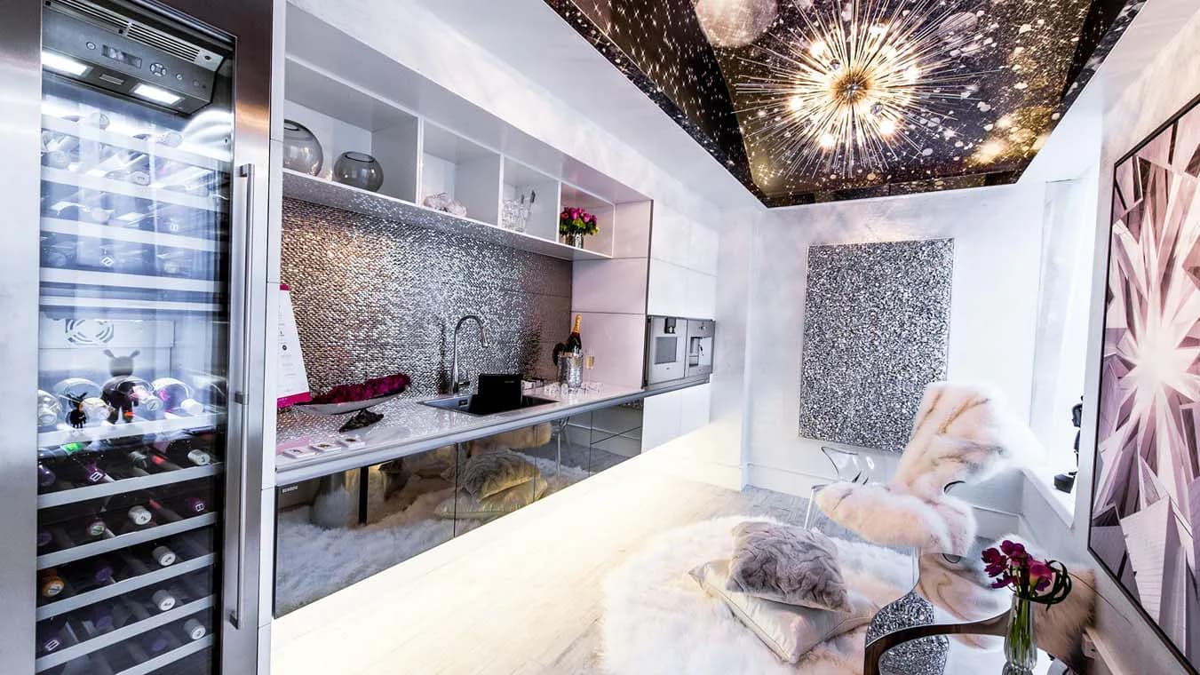 Luxurious bedroom interior with marble flooring, built-in mirrored cabinetry, textured accent wall, and decorative ceiling fixture designed by Noelia Ibanez.