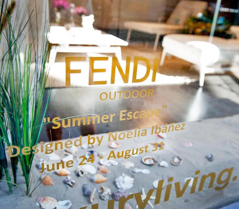 Outdoor terrace design featuring modern furniture, potted plants, and stone flooring with gold branding text for 'FENDI OUTDOOR Summer Escape' by Noelia Ibanez.