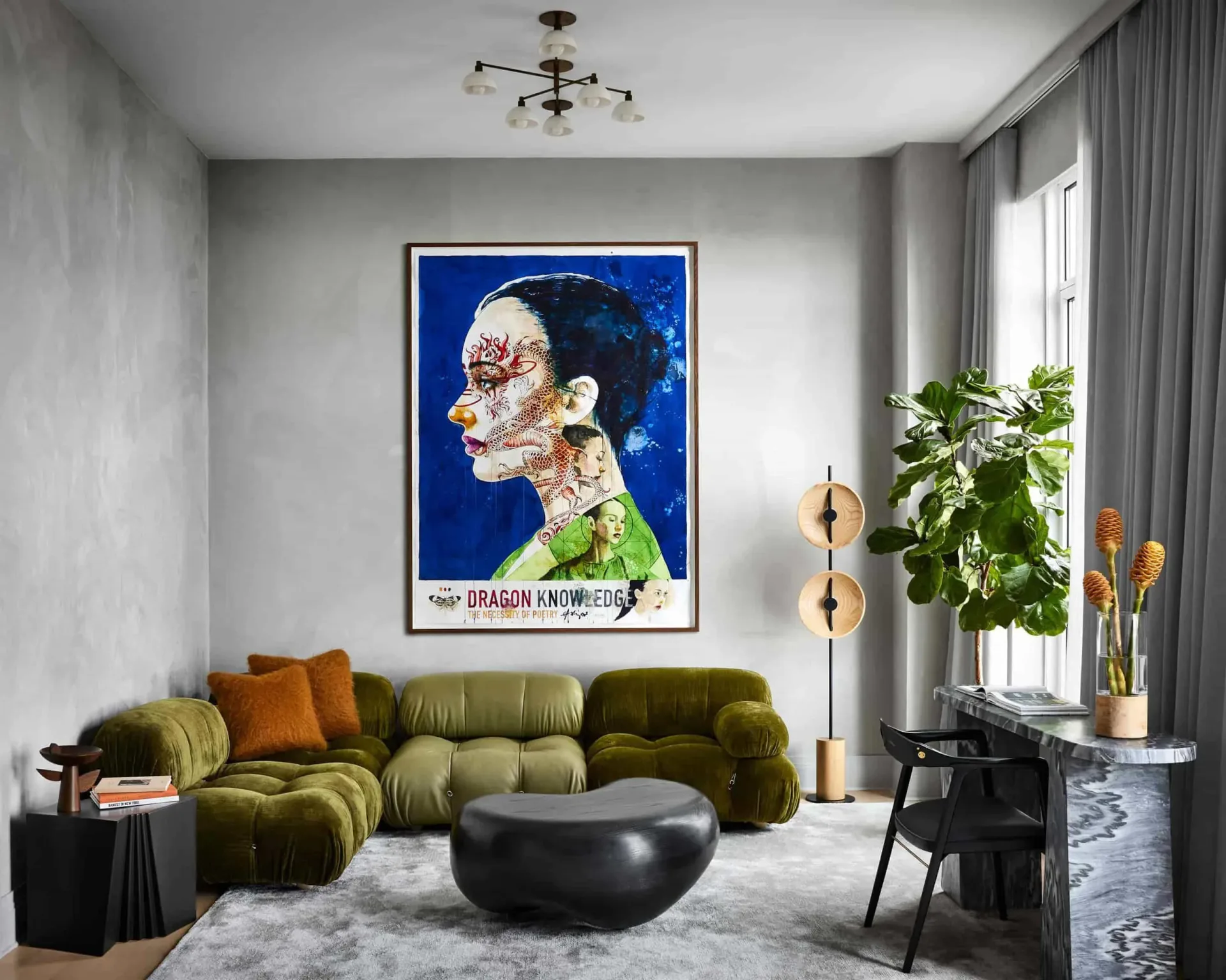 Modern living room with olive-green curved sectional, dark round ottoman, and abstract blue portrait artwork, designed by Noha Hassan.