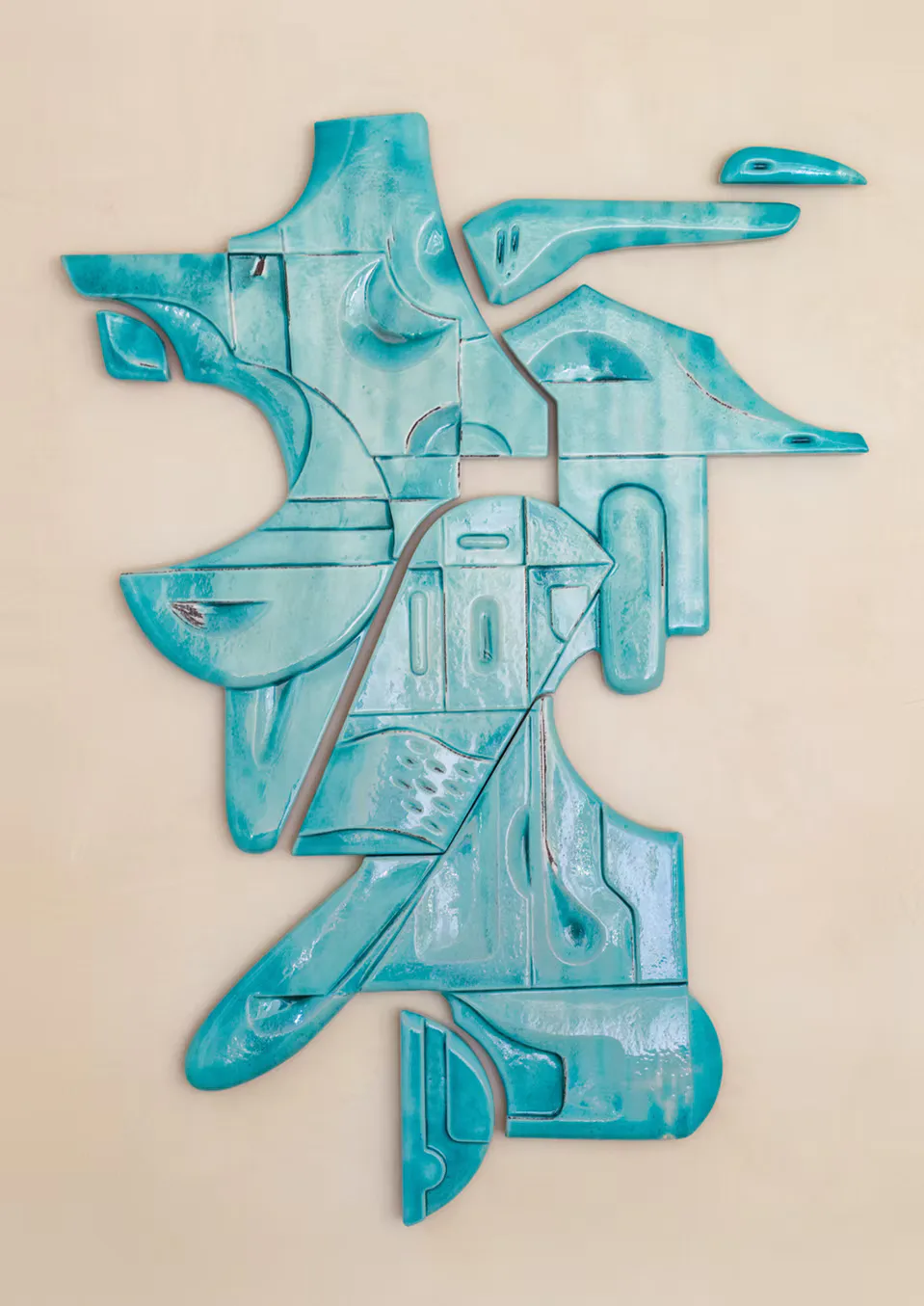 Turquoise metal wall sculpture with layered abstract forms and organic shapes, creating dimensional architectural composition by Olivia Cognet.