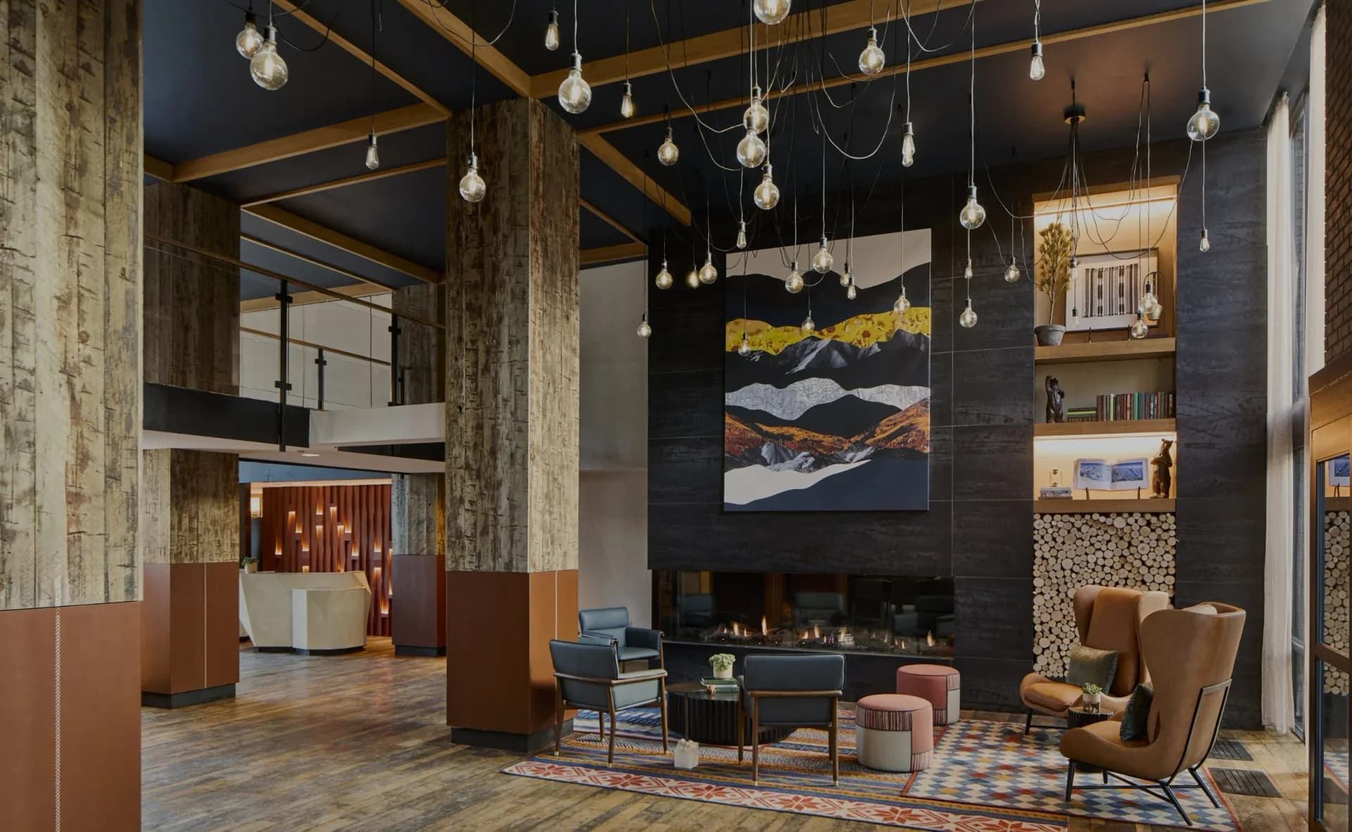 Modern hotel lobby with dark walls, wooden beams, pendant lighting, fireplace, and geometric patterned flooring by Olivia Cooper.