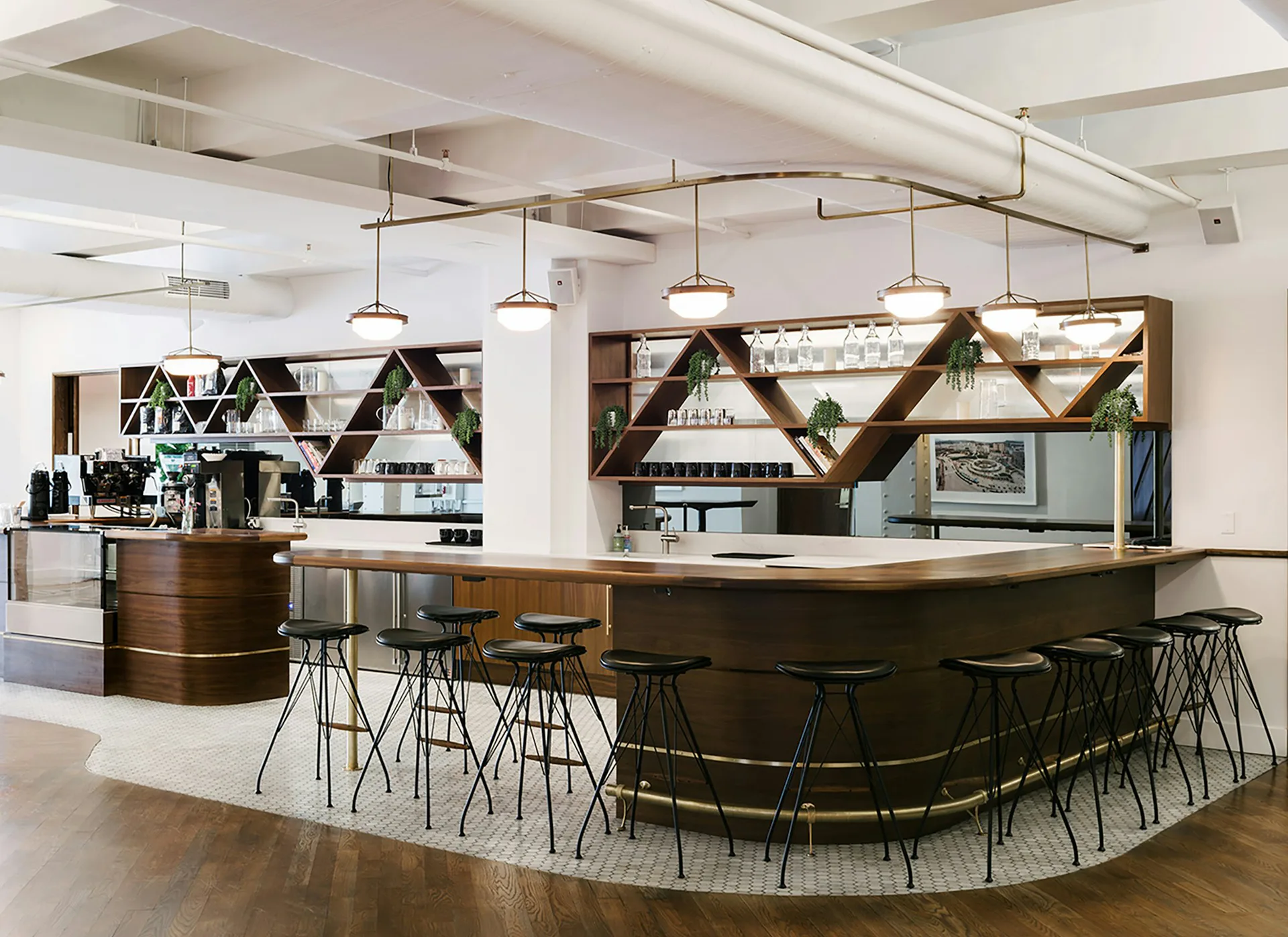 Contemporary bar and lounge interior with curved dark wood counter, geometric wooden lattice screens, pendant lighting, and bar seating by Pam Chaiyachakorn.