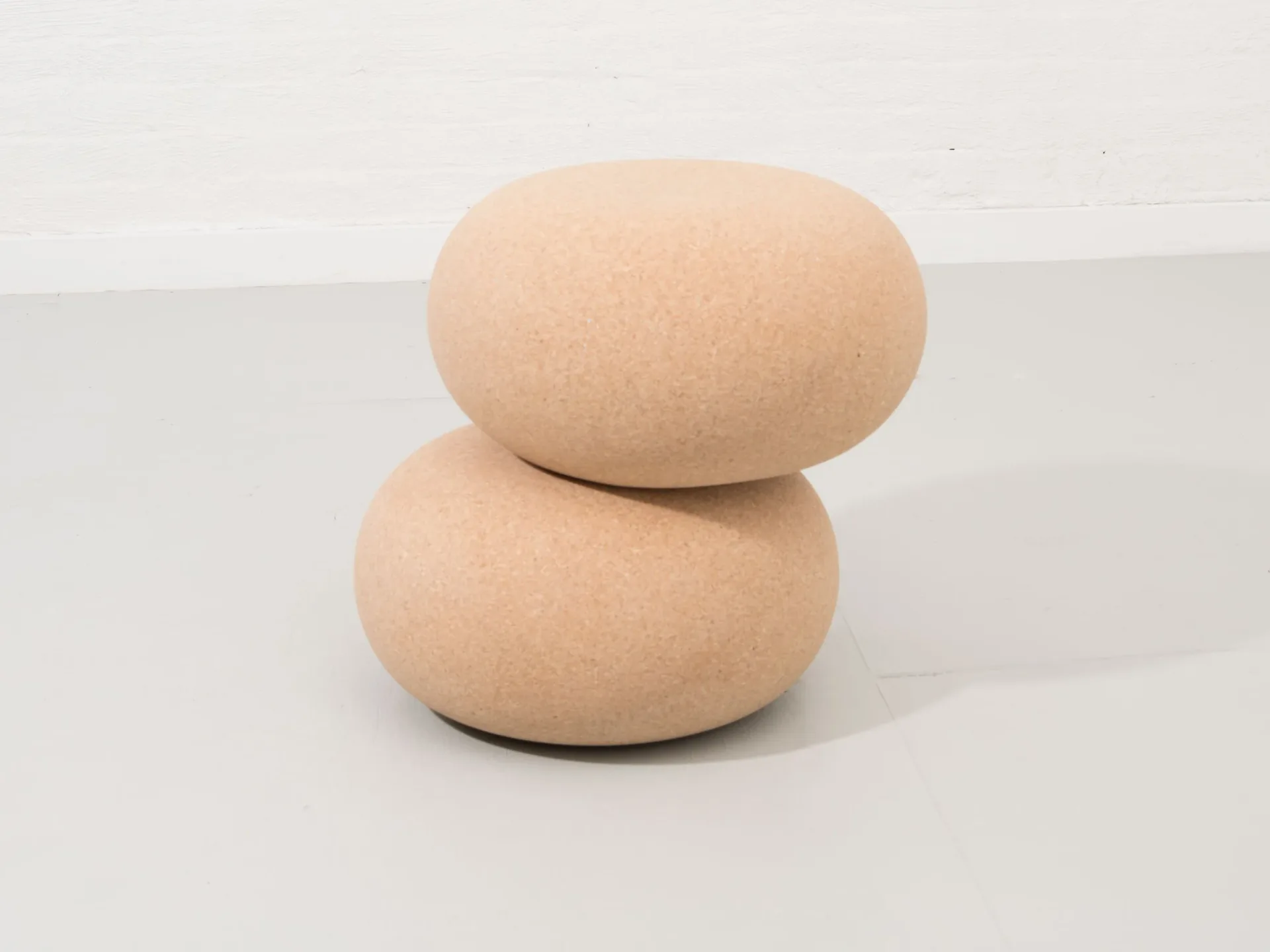 Two stacked terracotta-colored ceramic forms with smooth, rounded surfaces and organic shapes, displayed against a white background by Pat Kim.