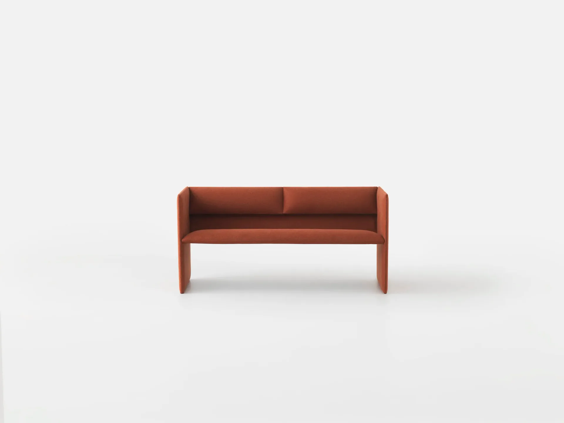 Rust-red upholstered bench with wooden frame and legs against neutral background, a minimalist furniture design by Philippe Malouin.