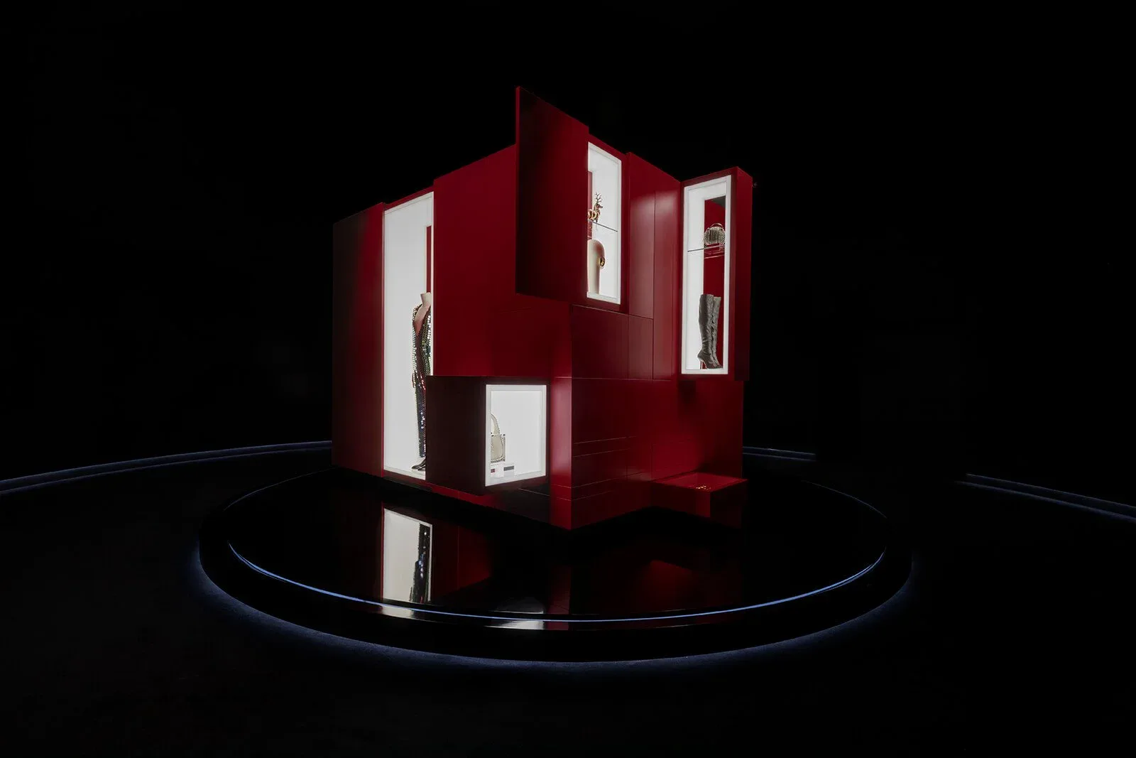 Deep red architectural installation with white window openings mounted on a circular platform against a black background, by Polina Zakh.