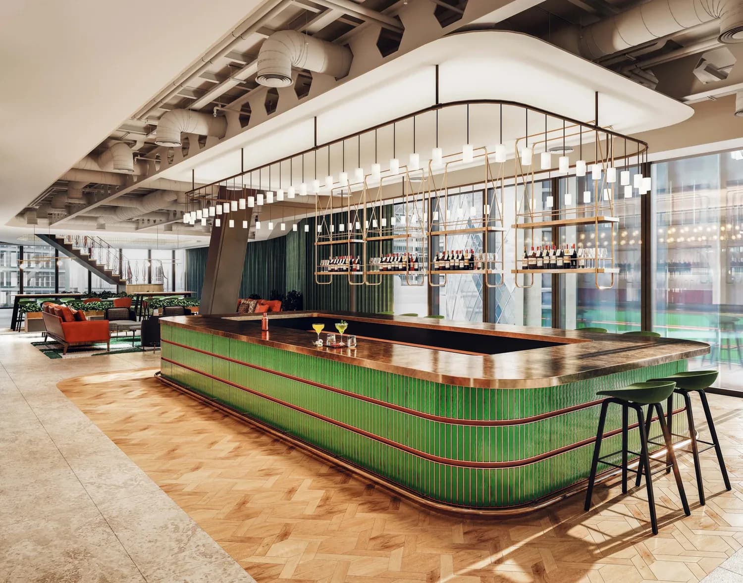 Modern bar interior with curved green ribbed counter, black top, suspended linear chandelier, and floor-to-ceiling windows overlooking greenery by Prutha Raithatha.