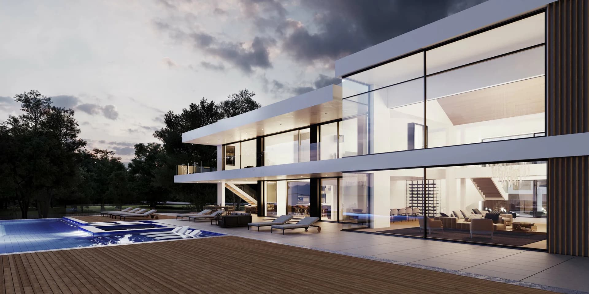 Modern two-story residential house with floor-to-ceiling glass walls, white and wood exterior, illuminated interior spaces, pool and wooden deck at dusk by Rachel Robarge.