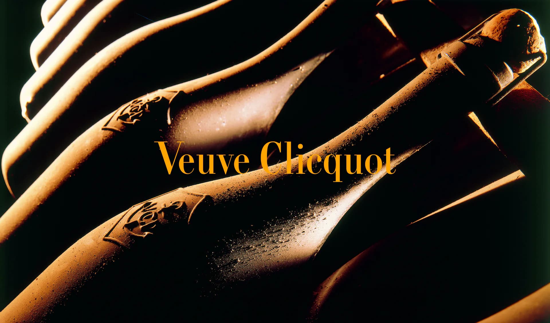 Luxury champagne bottles with golden lighting and Veuve Clicquot branding on dark background, styled product photography by Reynald Philippe.