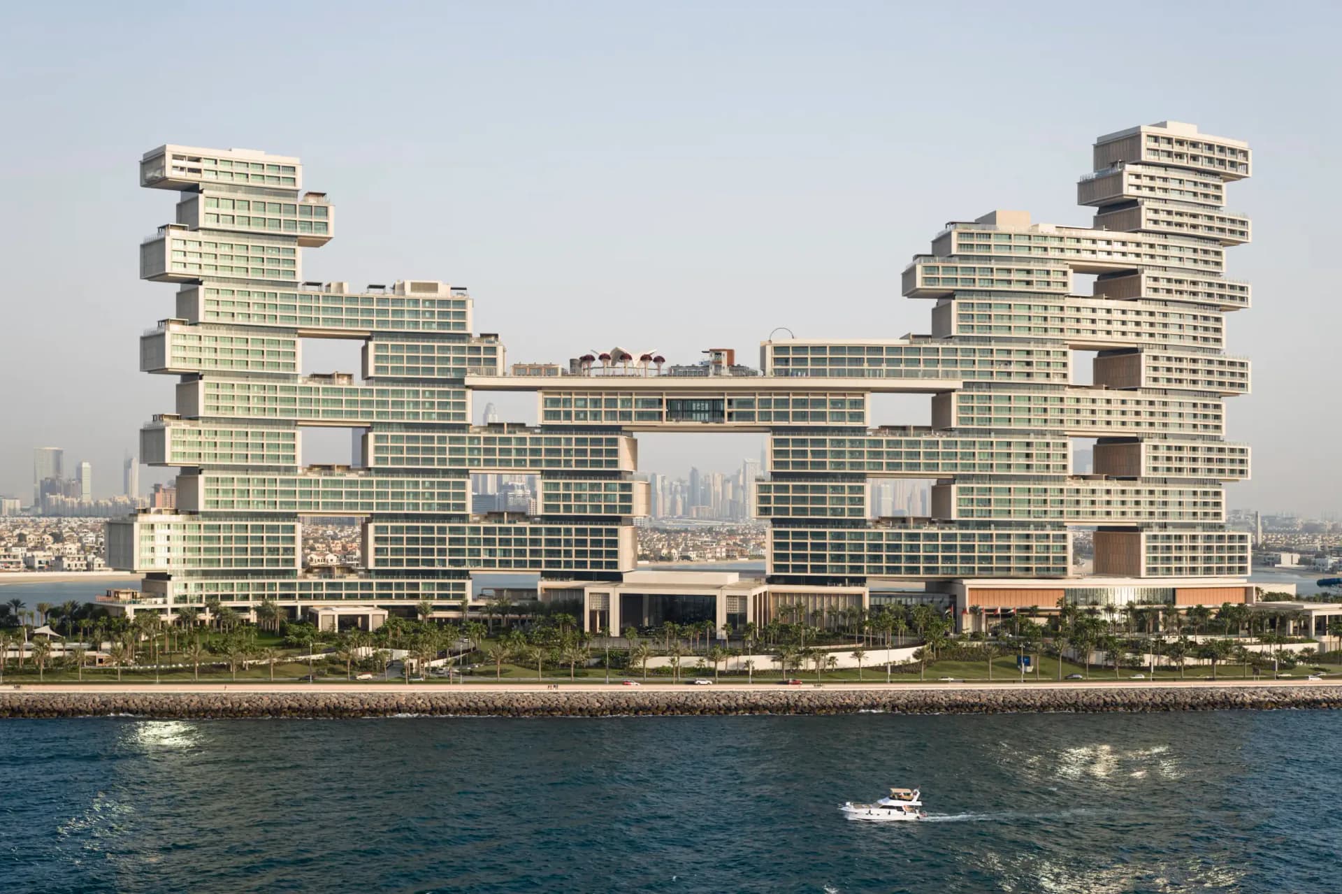 Waterfront residential complex with staggered yellow-green towers and brown accent sections overlooking blue water, by Richard Nemeth.