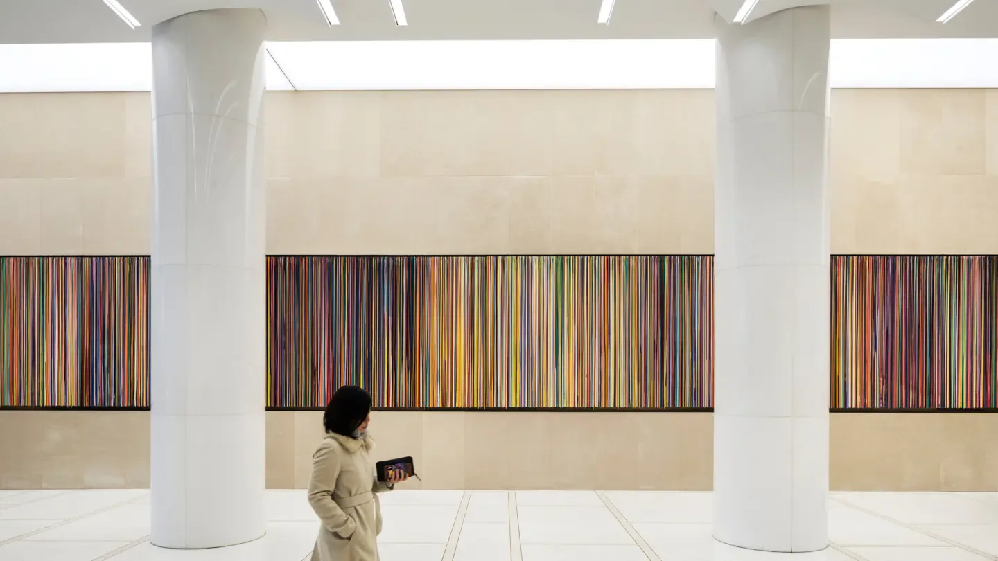 Minimalist gallery space with white columns, beige walls, and three framed abstract striped artworks by Richard Nemeth.