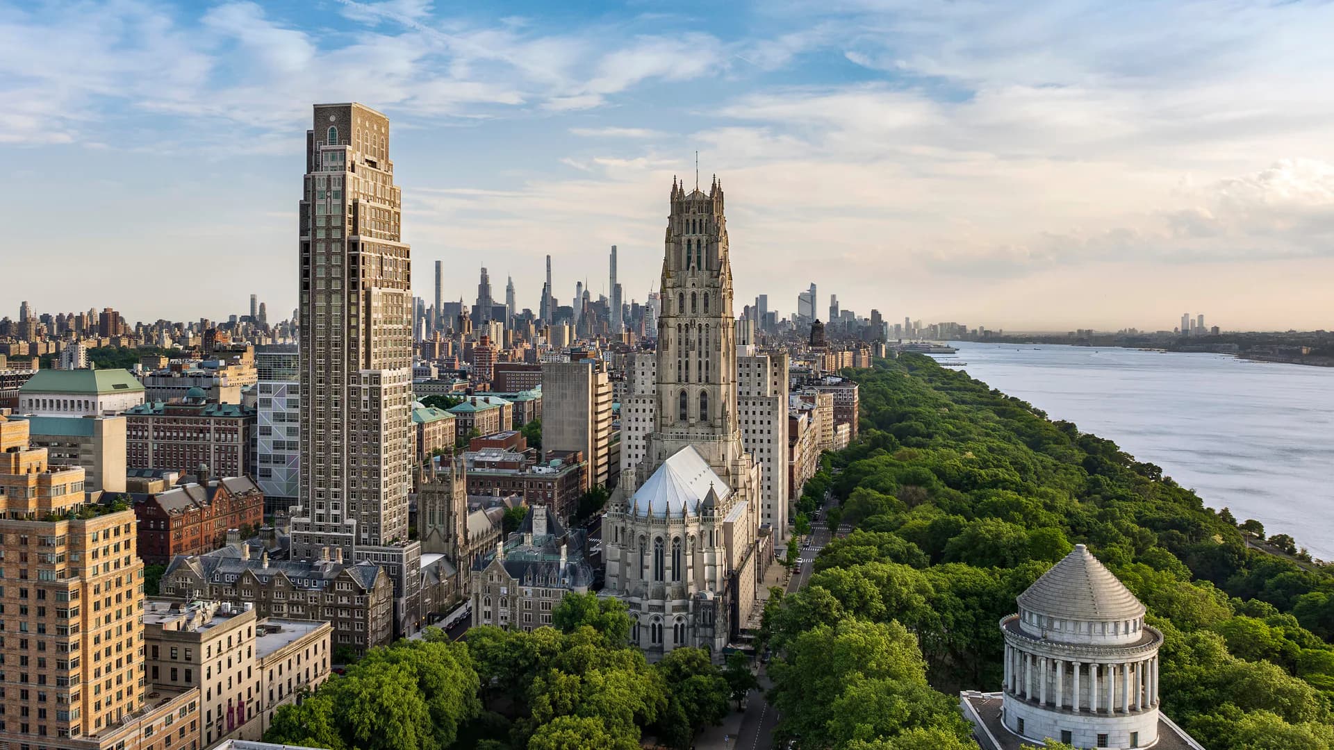Aerial view of New York City skyline featuring Gothic Revival towers and green waterfront park, designed by Robert A.M. Stern.