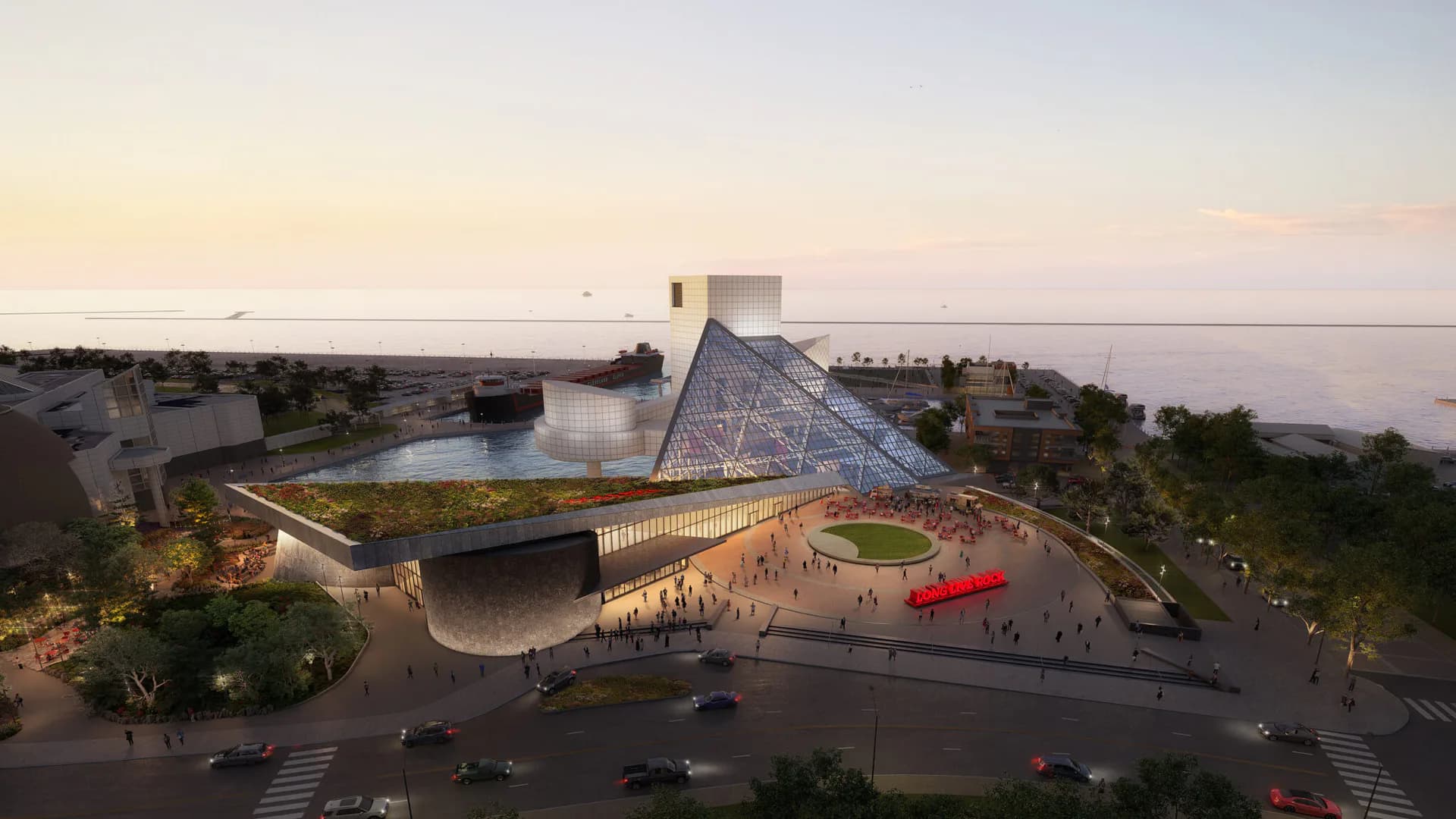 Waterfront cultural building with geometric angular architecture, green roofing, and public plaza with pedestrians at dusk by Ruchika Modi.