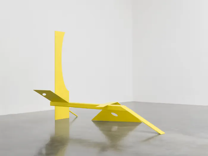 Abstract yellow geometric sculptural form with angular planes and folded surfaces photographed against a neutral background, by Samuel Ross.