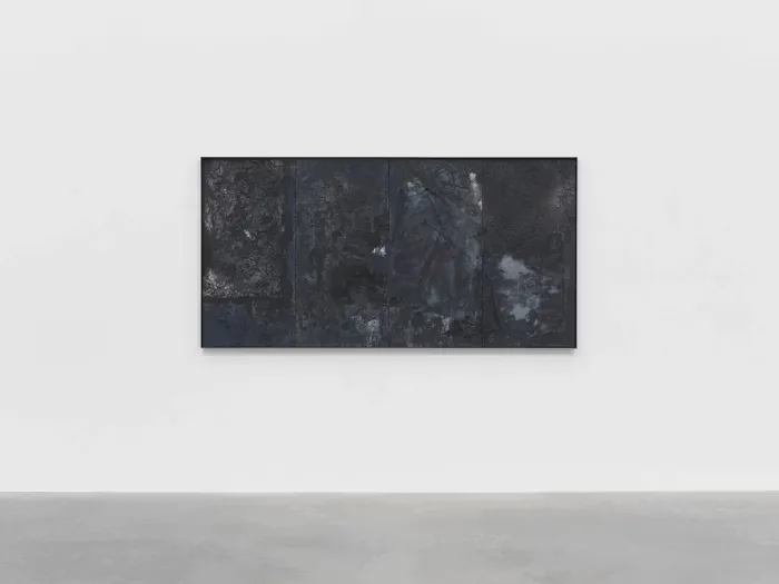 Dark textured wall installation with layered abstract forms and weathered surface finishes, contemporary art piece by Samuel Ross.