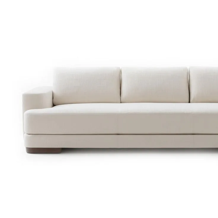 Minimalist cream upholstered sofa with low-profile base and modular seating arrangement by Shane Reilly.
