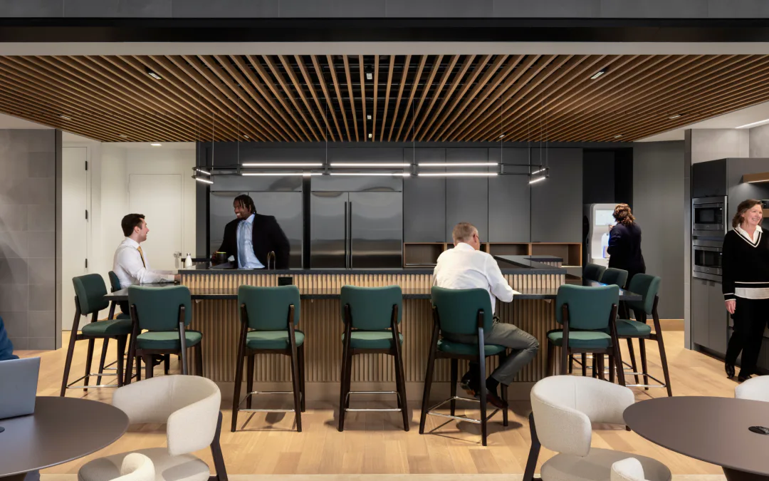Modern office lounge with wood-slat ceiling, green upholstered seating, and floor-to-ceiling windows, designed by Shant Madjarian.
