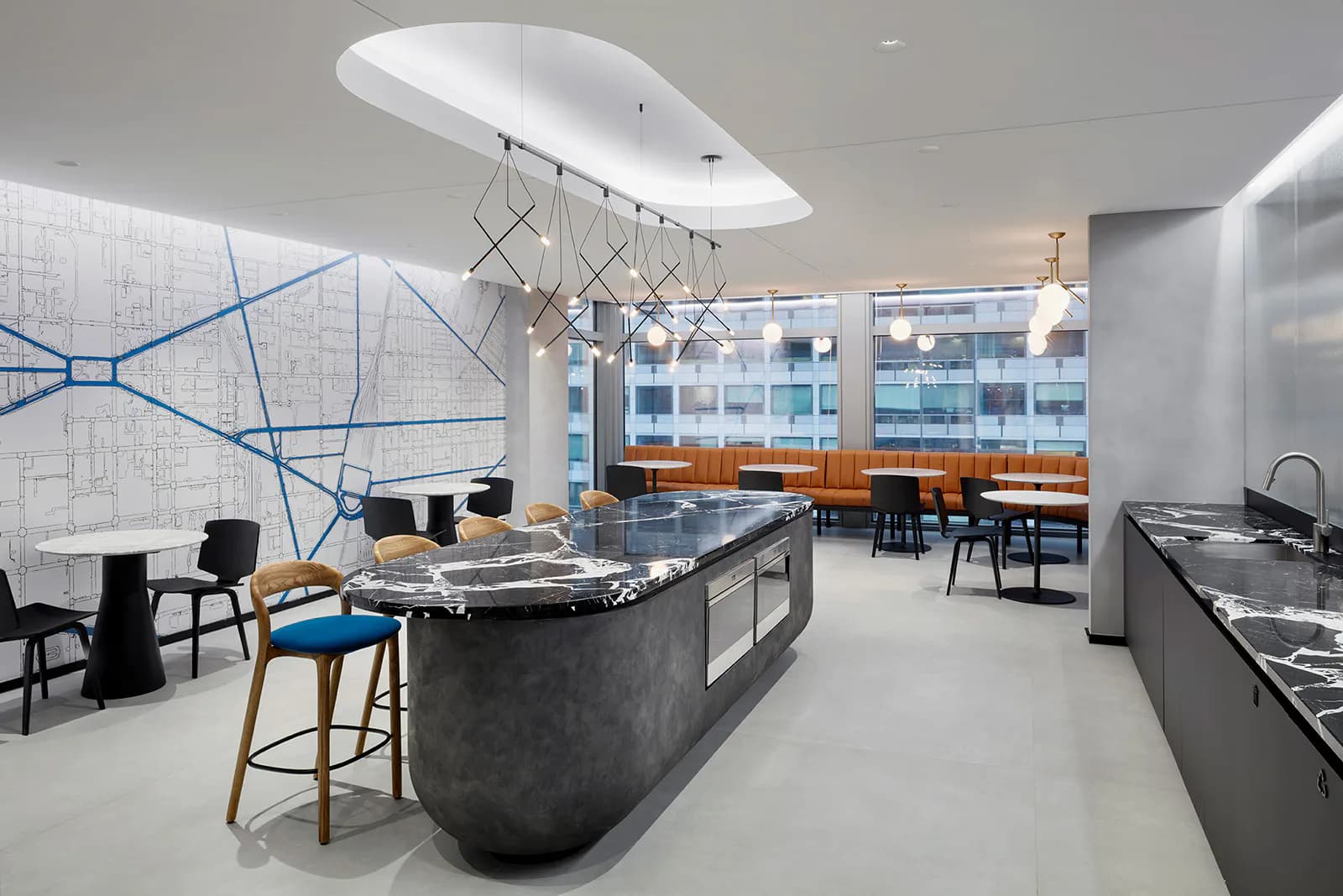 Modern kitchen and dining space with curved island, geometric pendant lighting, floor-to-ceiling windows, and blue linear wall graphics, designed by Shurouq Al Jammal.