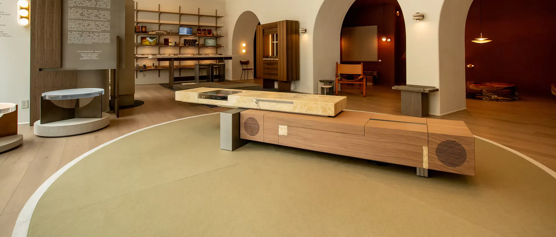 Minimalist interior space with polished concrete flooring, arched doorways, and sculptural wooden furniture by Simon Hamui.