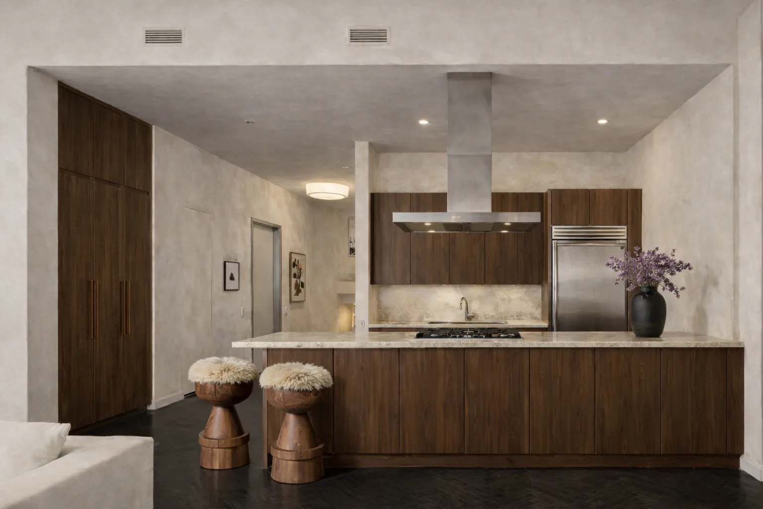 Modern kitchen with dark wood cabinetry, waterfall island, stainless steel appliances, and cream marble backsplash, designed by Simone Lawton.