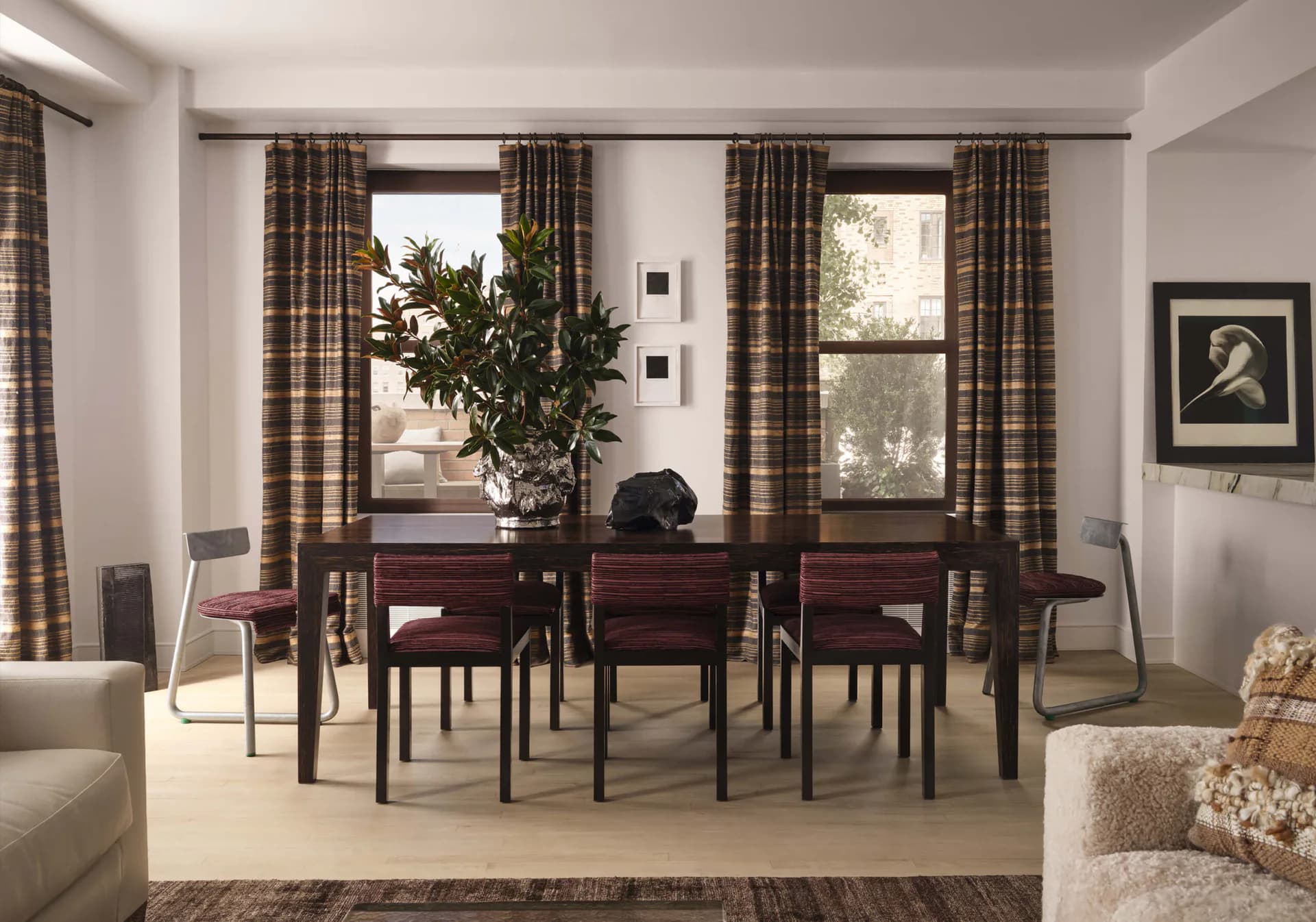 Contemporary dining room with dark wood table, plaid curtains, large windows, and neutral palette, designed by Soo Chung.