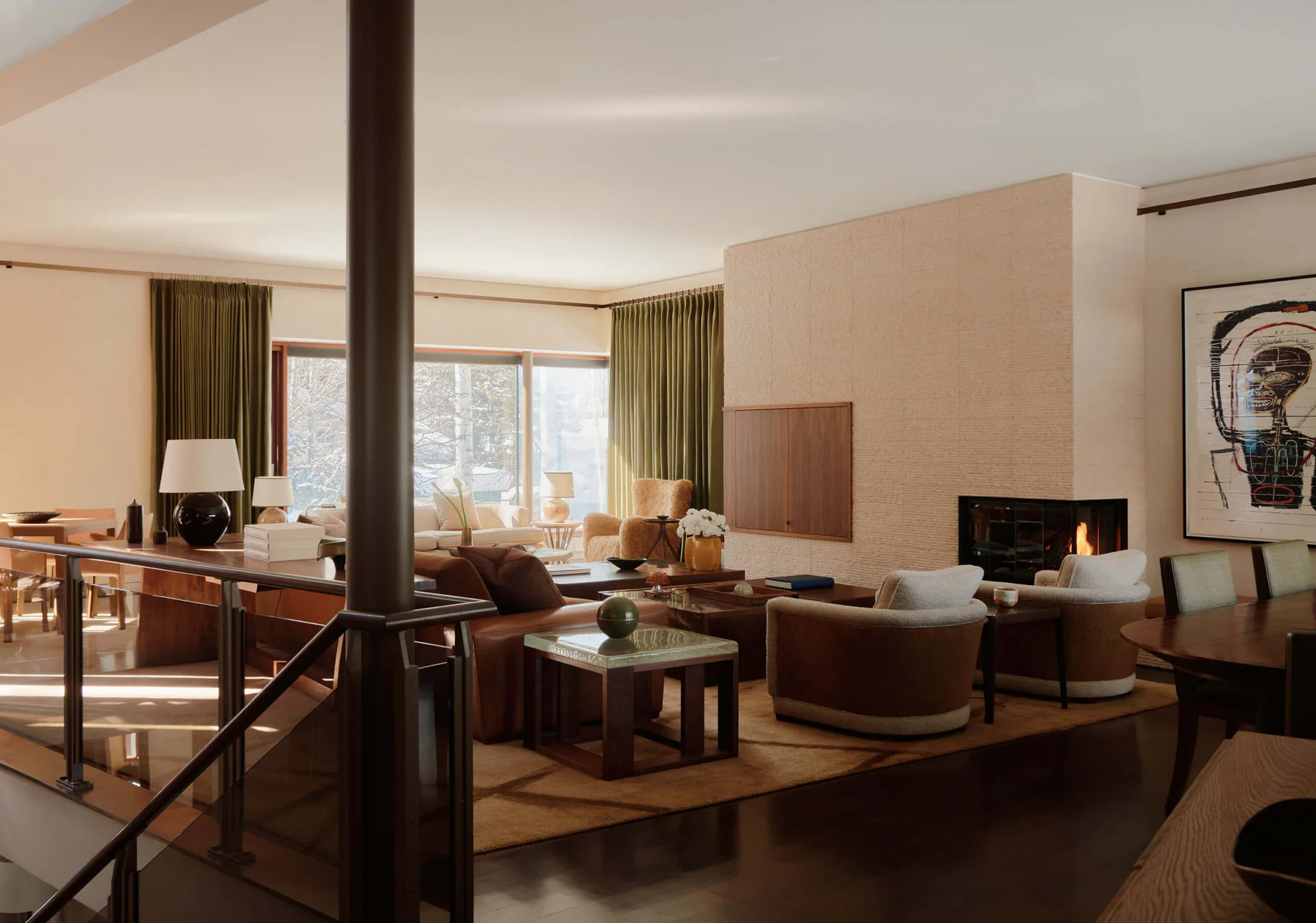 Luxurious modern hotel suite with warm wood tones, floor-to-ceiling windows, brown leather seating, and contemporary furnishings designed by Soo Chung.