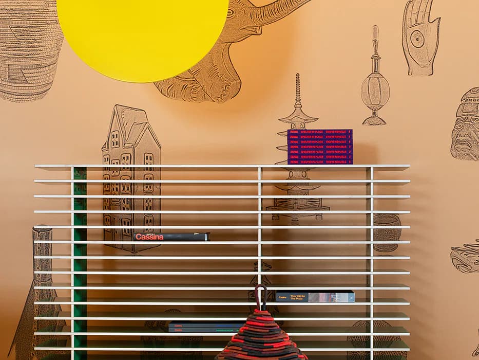 Architectural elevation drawing with horizontal line work, colored panels, and decorative objects suspended against a warm beige background by Stephen Burks.