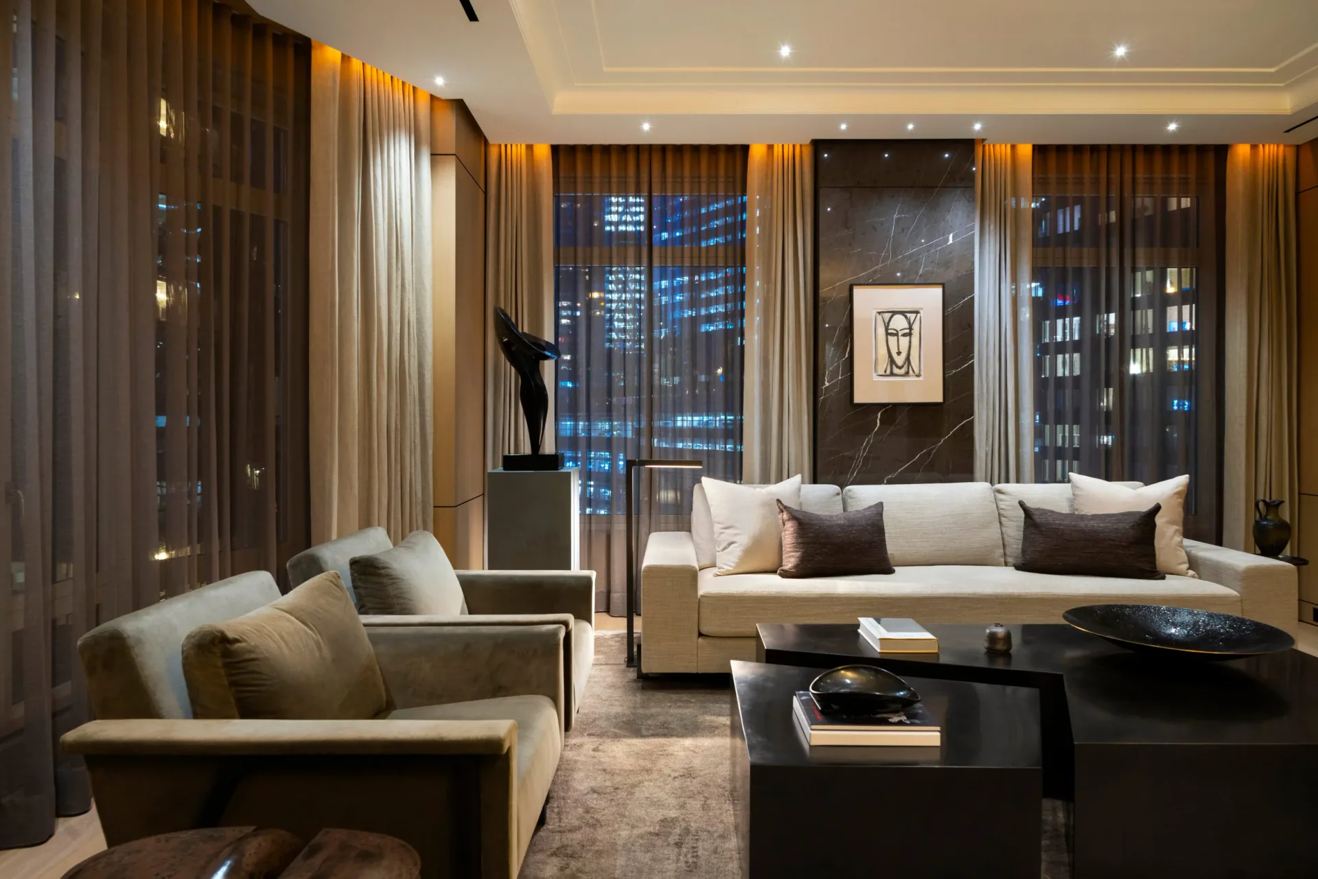 Luxury living room with cream sectional, black coffee table, golden curtains, and city views by Tanishkaa Kumar.