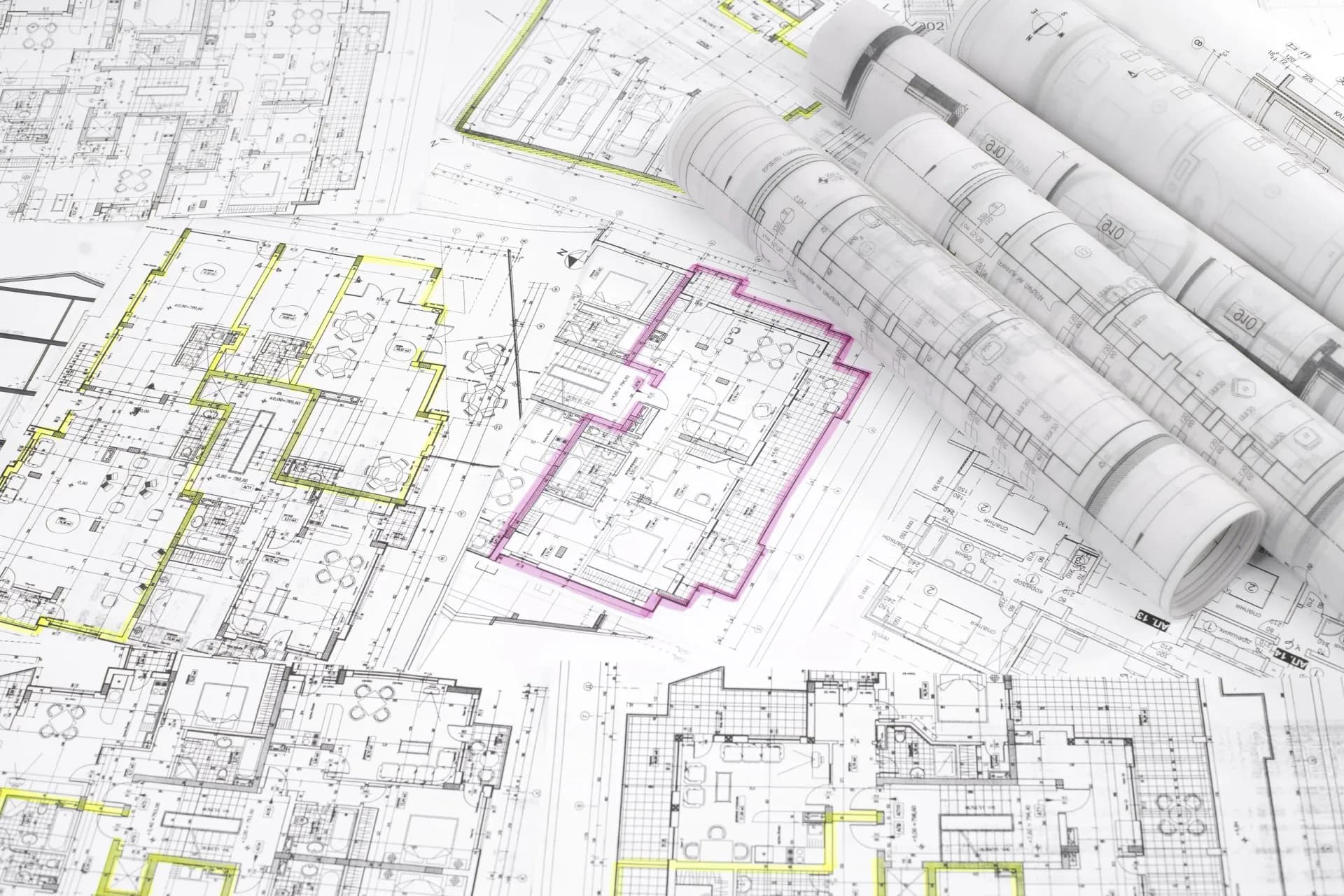 Architectural floor plans with yellow and pink highlighted areas and rolled blueprints, showing detailed layouts and design annotations by Terry Sachs.